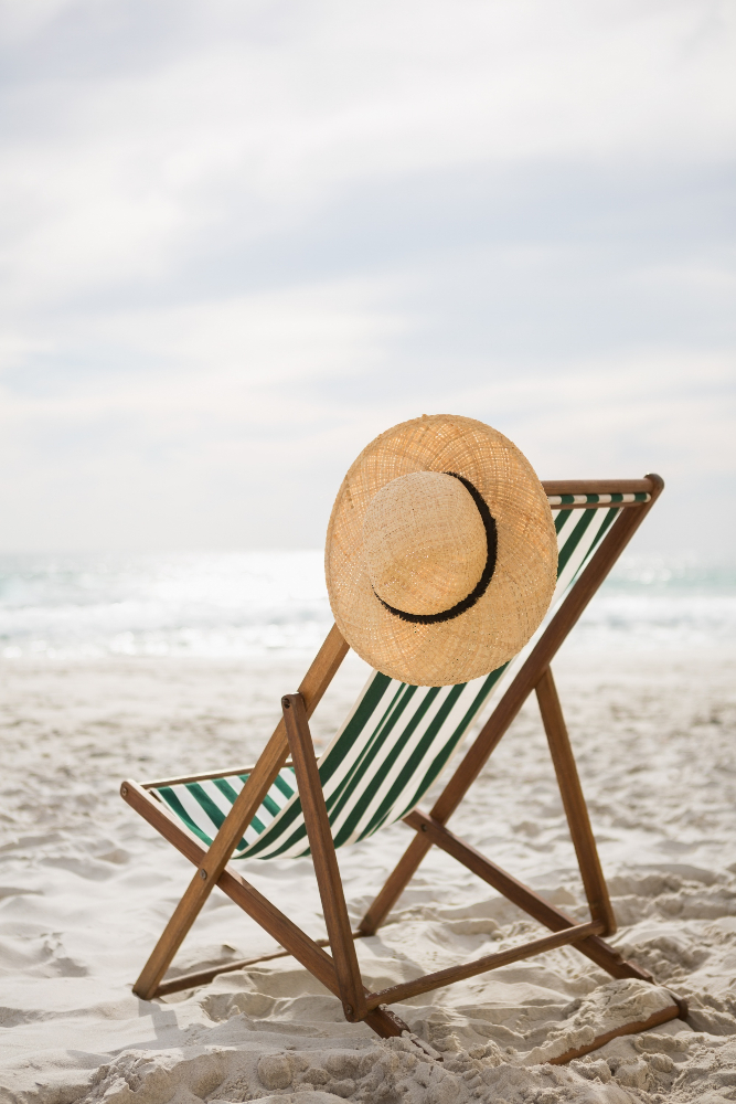 Straw hat on a deck chair at the beach